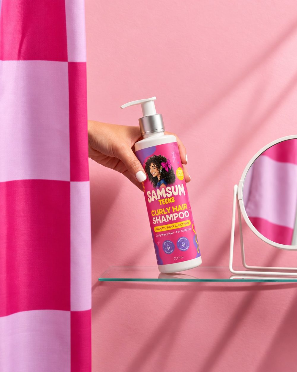 Samsum Teens Curly Hair Shampoo on a glass shelf next to a mirror